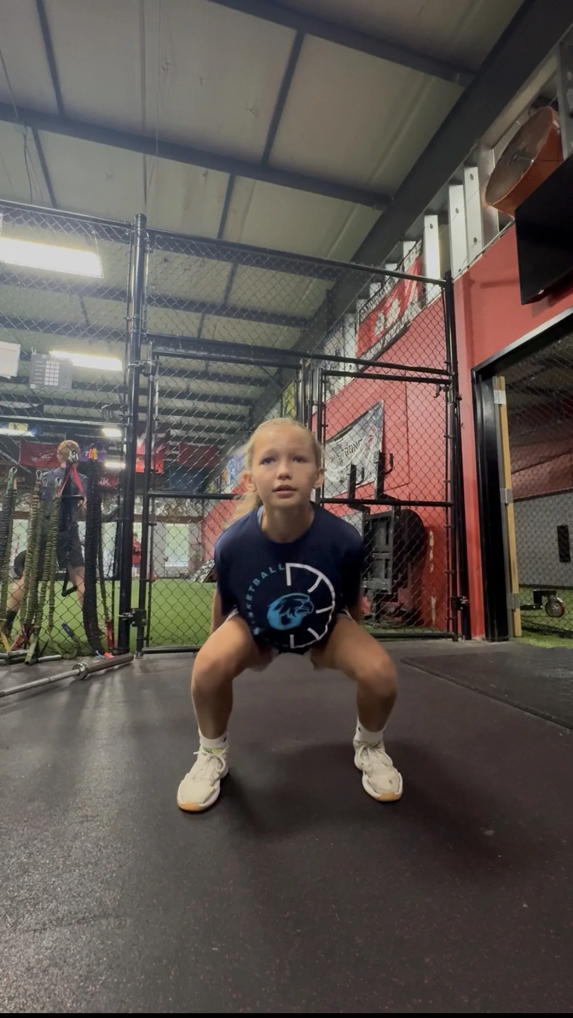A young athlete absorbing a landing with her knees tracking over her toes